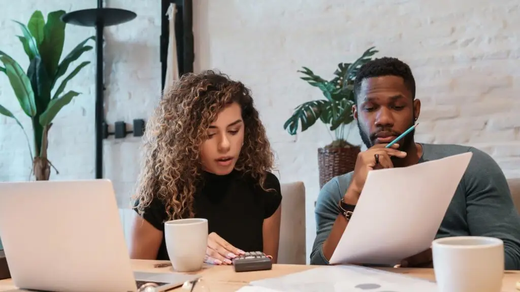 Comment calculer son budget pour acheter un bien immobilier en Belgique ? 1 couple calculant le budget pour acheter un bien