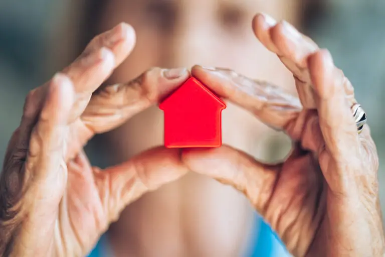agent immobilier tenant une maison miniature