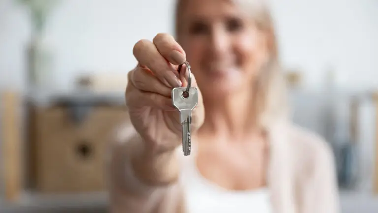 Femme souriante tenant une clé