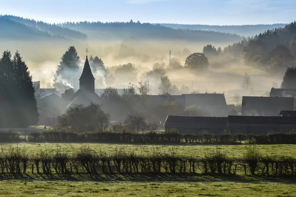 paysage paisible en brume avec une église au cœur d'un village