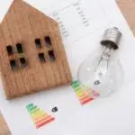 maison écologique en bois et ampoule sur papier